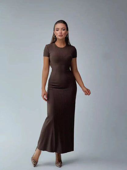 Elegant woman modeling a dark brown ribbed knit maxi dress with a sleek silhouette, perfect for casual or formal occasions.