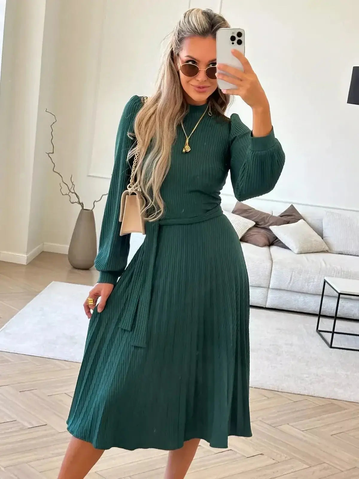 Model in an emerald midi dress showcasing pleated elegance, perfect for weddings, parties, and formal occasions.