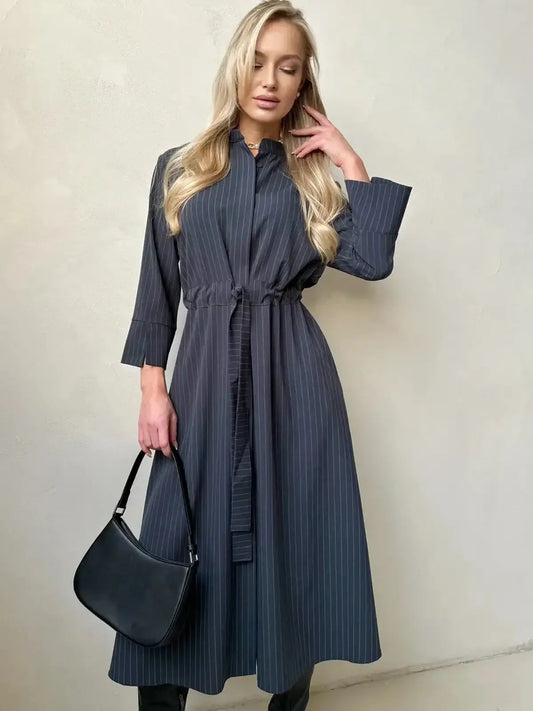 Model wearing a stylish Slate Stripe Midi Dress with a soft waist tie, showcasing a sophisticated look for various occasions.