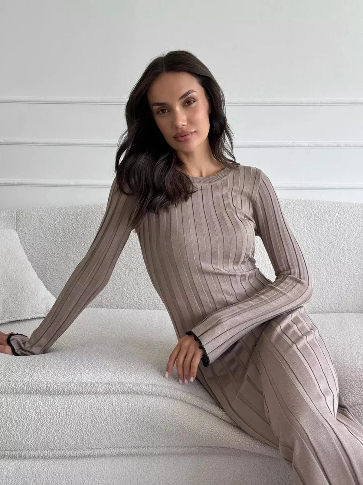 Stylish woman wearing the Contour Maxi Dress, showcasing ribbed knit elegance and long sleeves in a neutral tone.