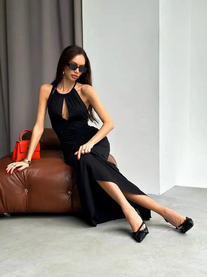 Elegant black maxi dress with halter neckline and keyhole cutout, styled for evening events.