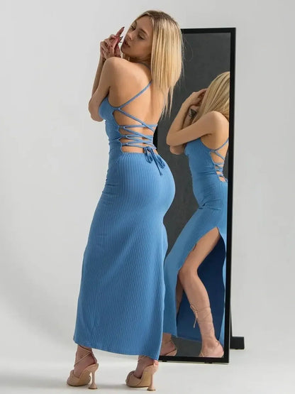 Model showcasing the Ocean Lace Midi Dress in blue with a ribbed texture, featuring a lace-up back and side slit.