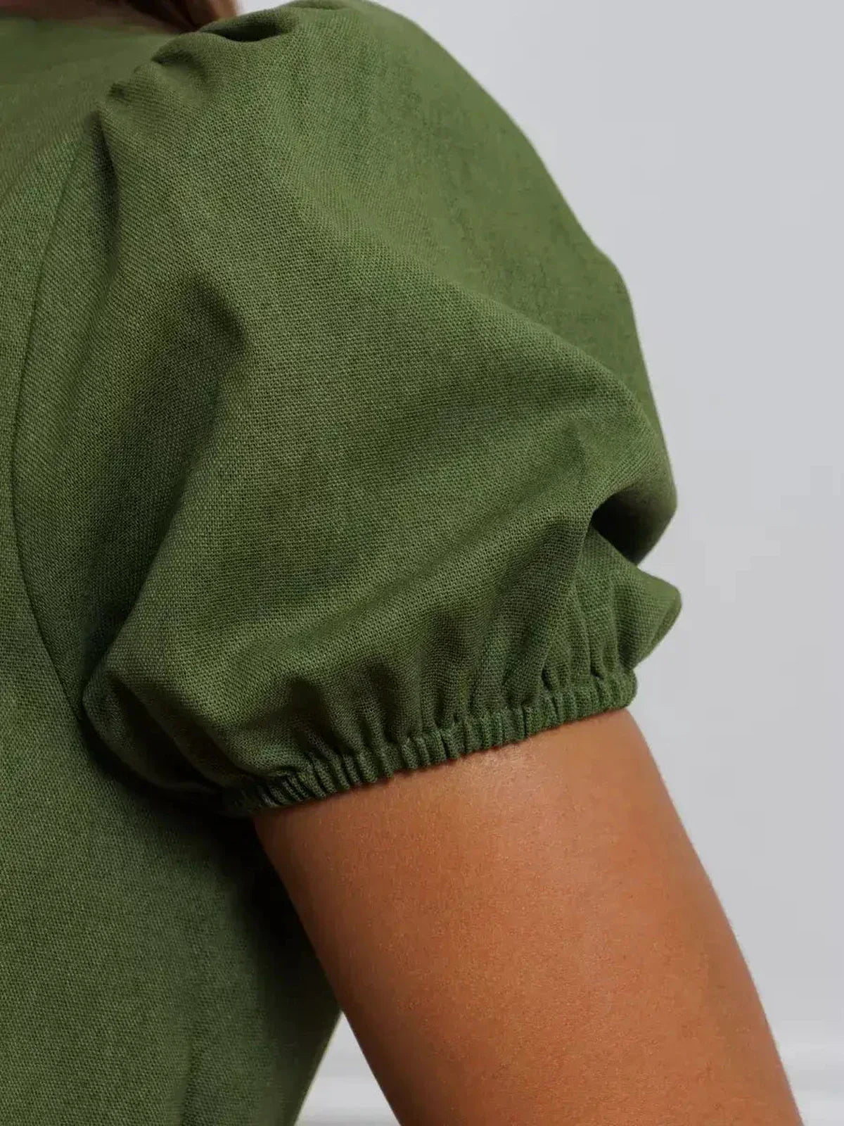 Detail view of puff sleeve on Olive Whisper Maxi Dress, showcasing its elegant khaki fabric and subtle gathering.