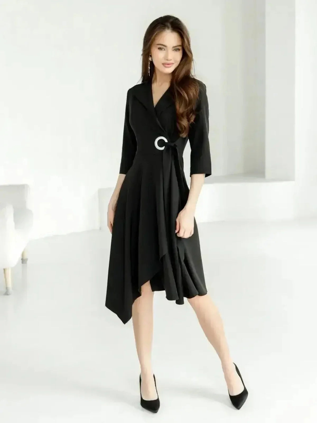 Elegant black midi dress with wrap silhouette, asymmetric hem, and silver-tone ring, perfect for wedding guest or formal occasions.