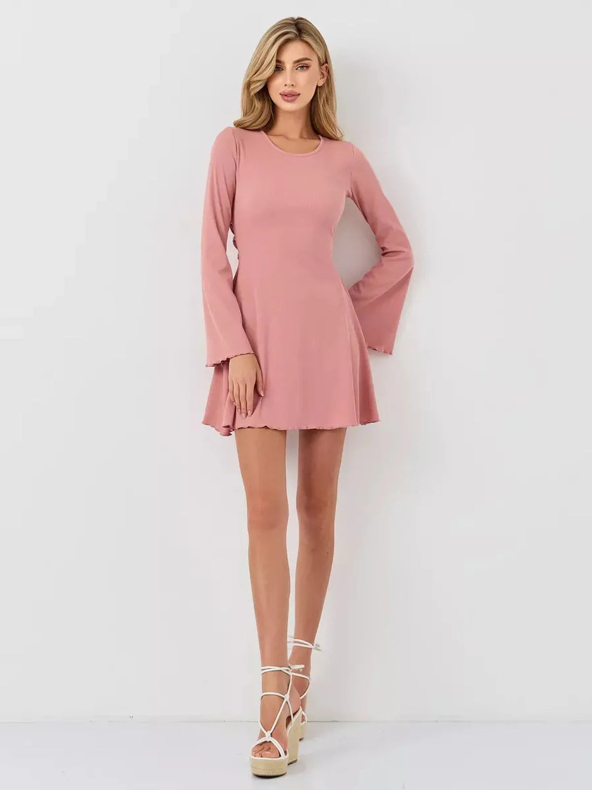 Elegant Blush Aura mini dress featuring a flattering A-line silhouette, long flared sleeves, and a smooth U-neckline.