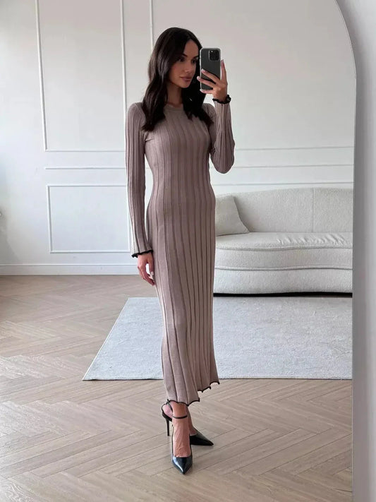 Model showcasing the elegant Contour Maxi Dress, highlighting its ribbed knit, full-length silhouette, and chic style.