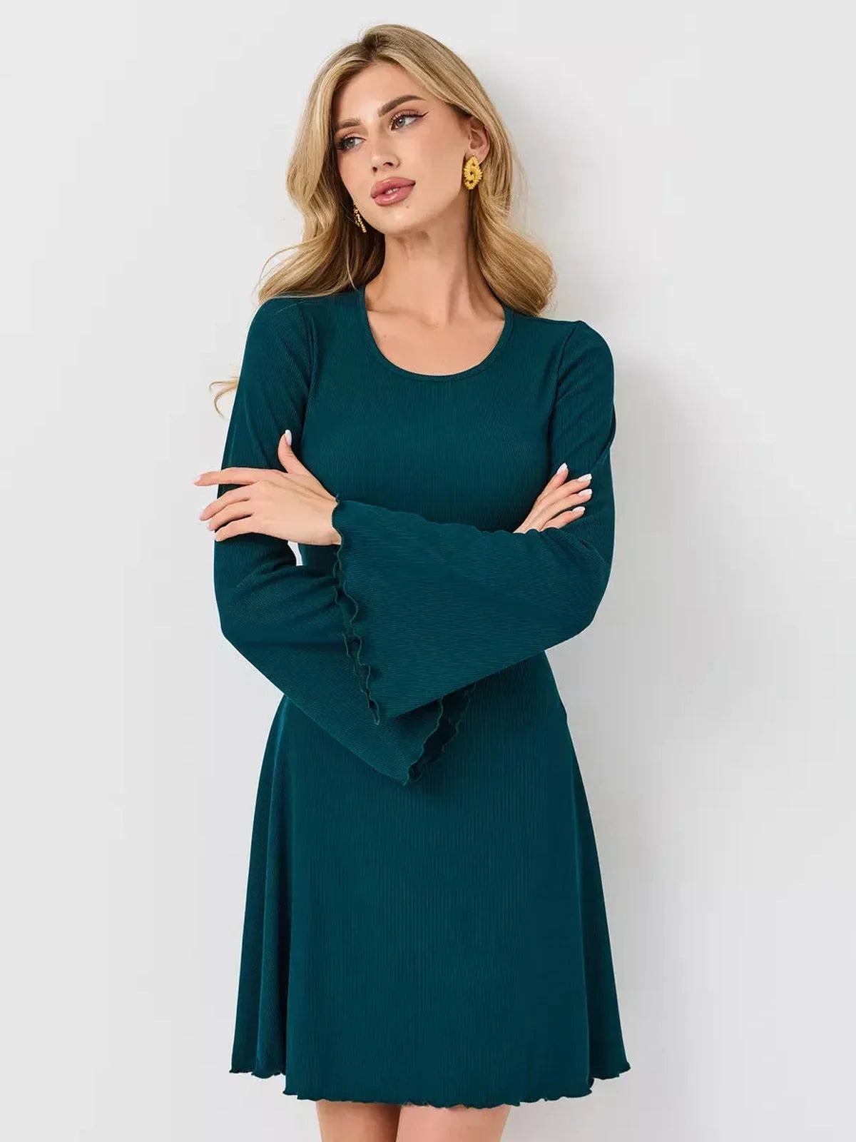 Emerald Whisper mini dress featuring a flared hem and bell sleeves, perfect for weddings and summer events.