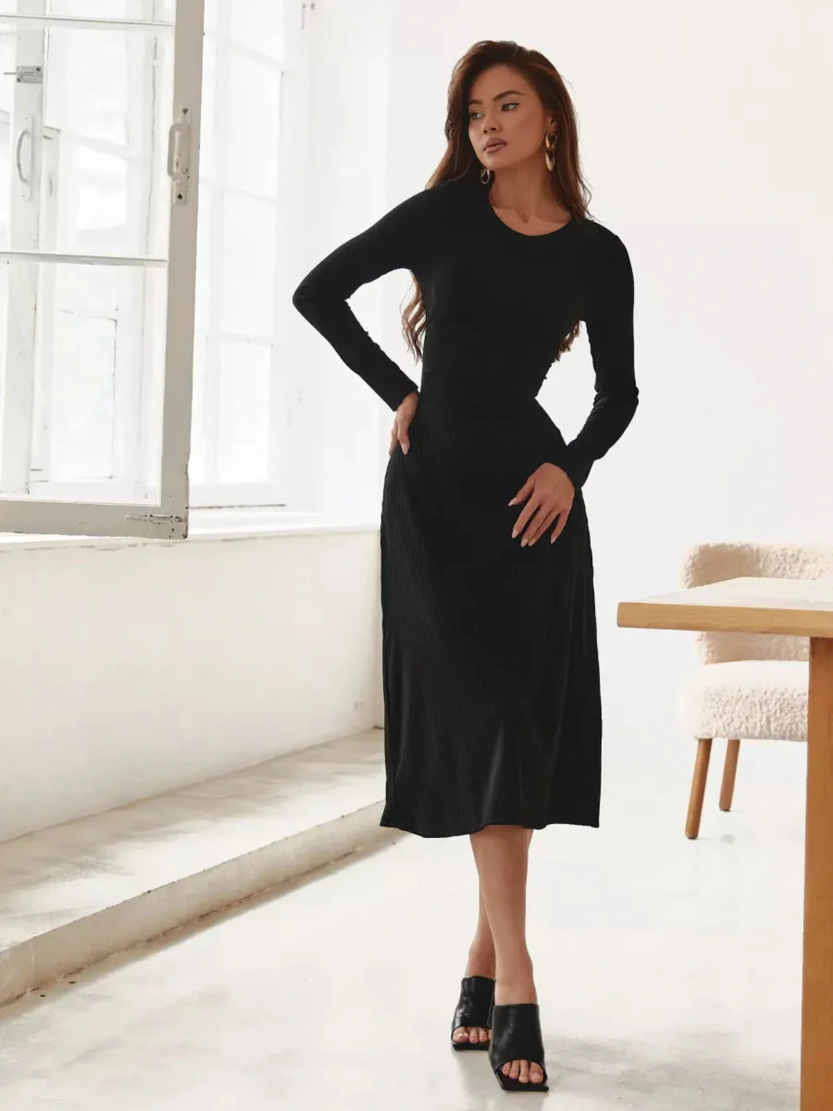 Model wearing a sleek black Luxe Lace Midi Dress, showcasing long sleeves and a chic A-line silhouette.