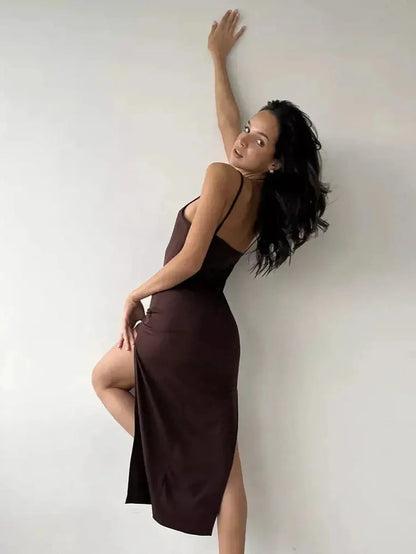 Model poses in the elegant Noir Muse Midi Dress, showcasing the deep chocolate satin and seductive side slit.