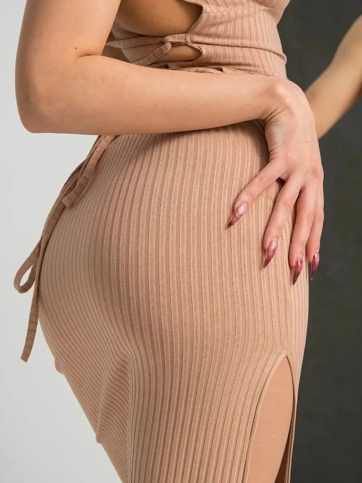 Close-up of a woman in a nude lace midi dress showcasing the ribbed fabric and thigh-high slit.