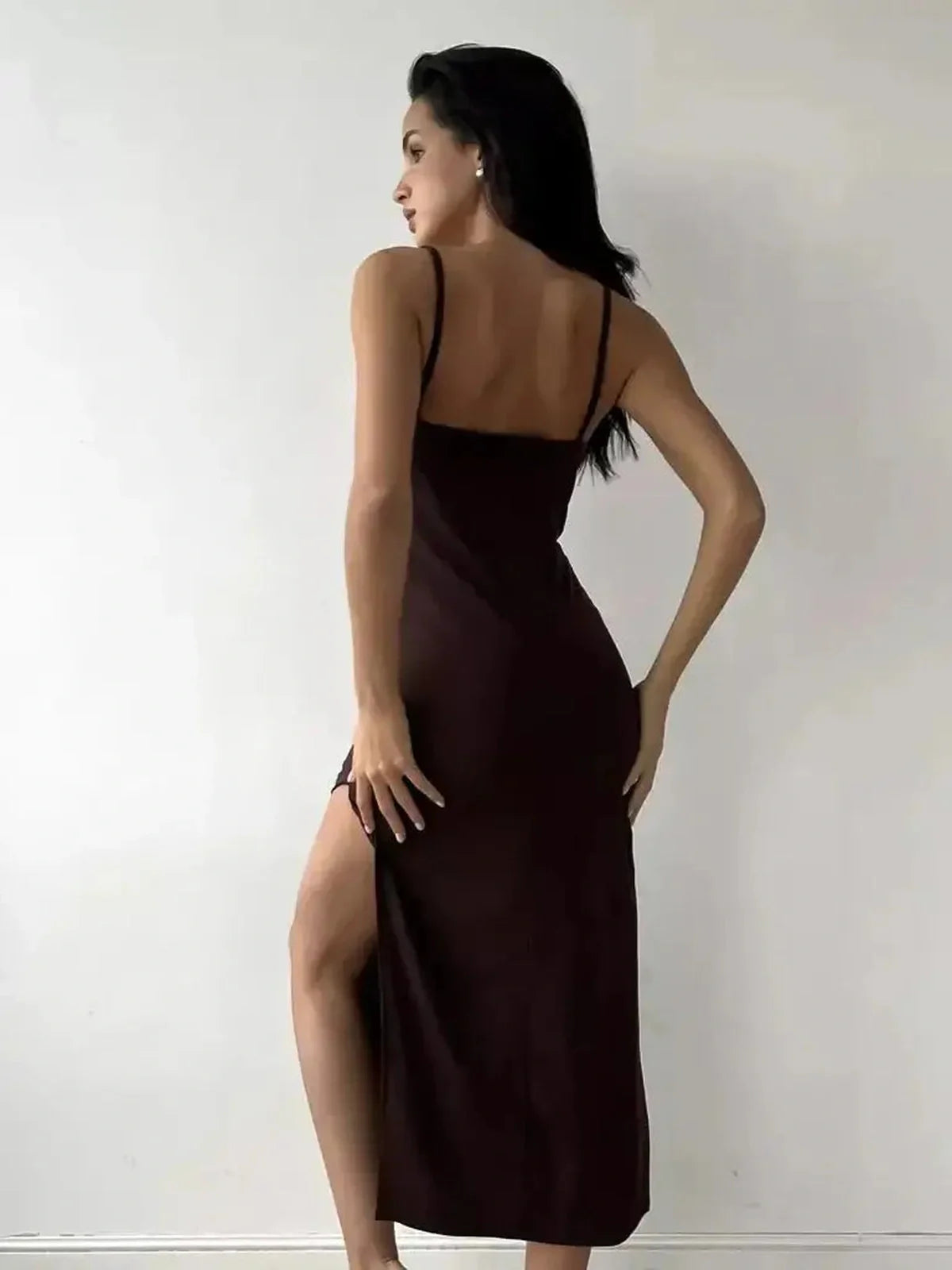 Model showcasing the Noir Muse Midi Dress in deep chocolate satin, featuring a side slit and elegant fit.