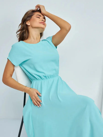 Elegant woman wearing a turquoise maxi dress, showcasing a relaxed fit and stylish design, perfect for summer and formal occasions.