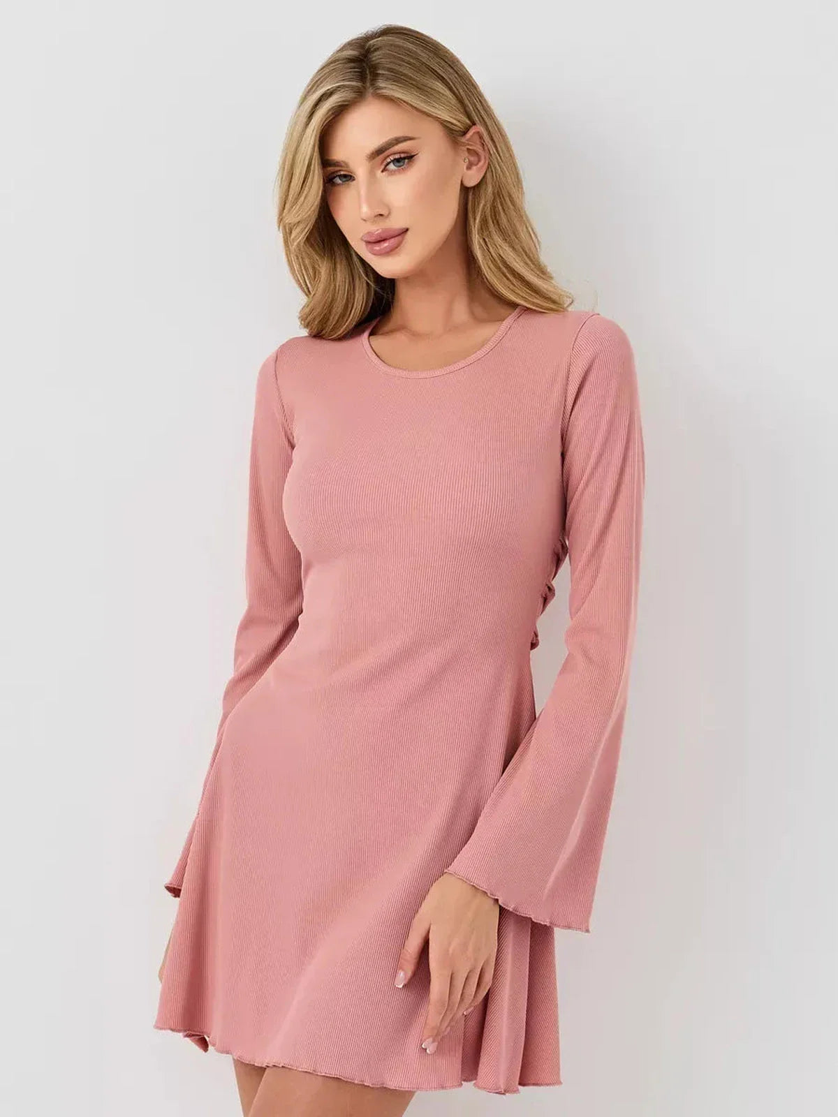 Model showcasing the Blush Aura mini dress with a U-neckline and flared sleeves, perfect for summer and special occasions.