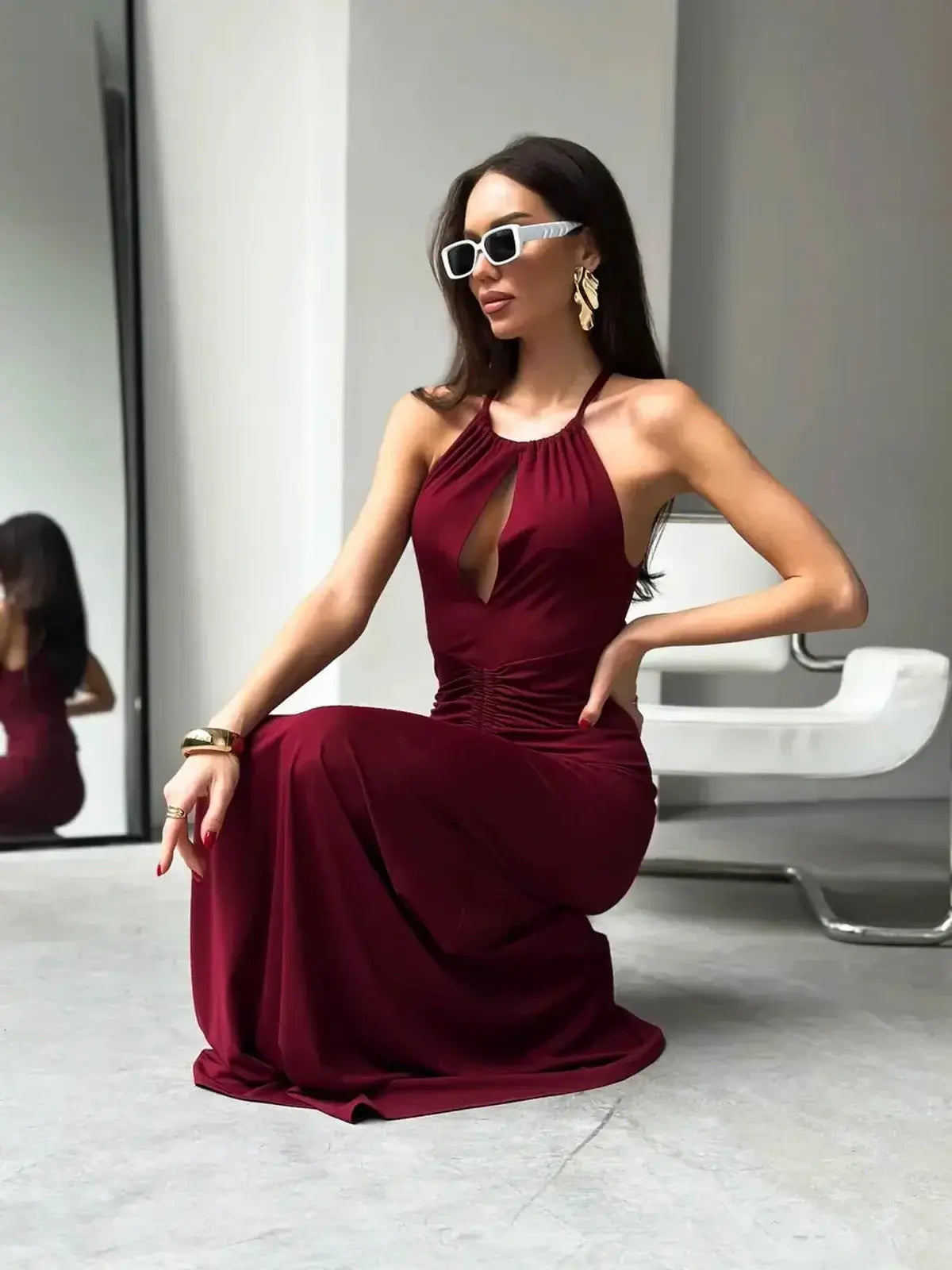 Sleek maxi dress in rich burgundy, featuring a halter neckline and ruched waist, perfect for formal occasions.