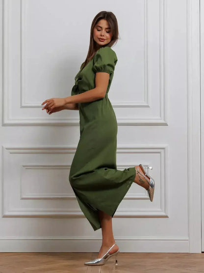 Model wearing Olive Whisper Maxi Dress with puff sleeves and tie front, showcasing earthy elegance and timeless style.