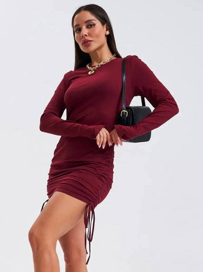 Burgundy Sculpt mini dress with long sleeves and side draping, perfect for wedding guests and parties.