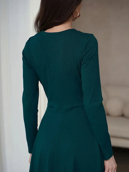 Back view of elegant emerald mini dress with long sleeves and ribbed texture, perfect for weddings and formal events.