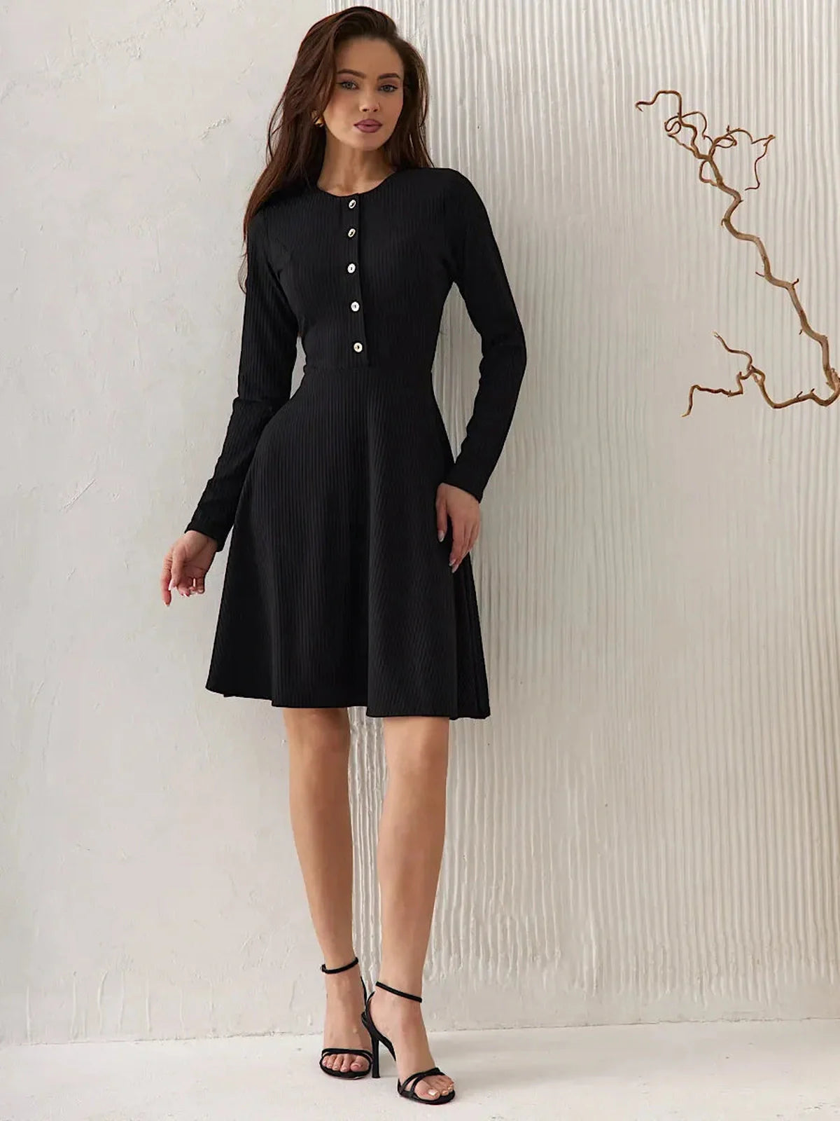 Elegant black mini dress with long sleeves, round neckline, and statement buttons, ideal for formal occasions and weddings.