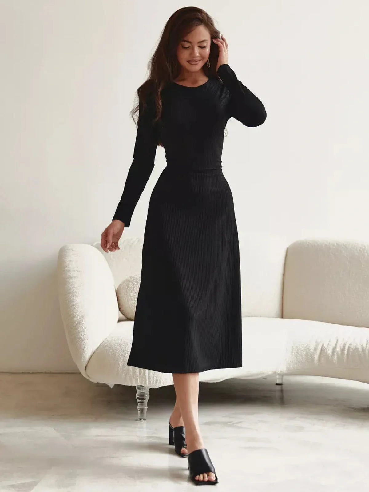 Elegant black midi dress with long sleeves, showcasing a flattering silhouette and minimalist style, perfect for any occasion.