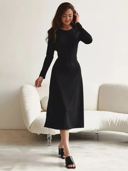 Elegant black midi dress with long sleeves, showcasing a flattering silhouette and minimalist style, perfect for any occasion.