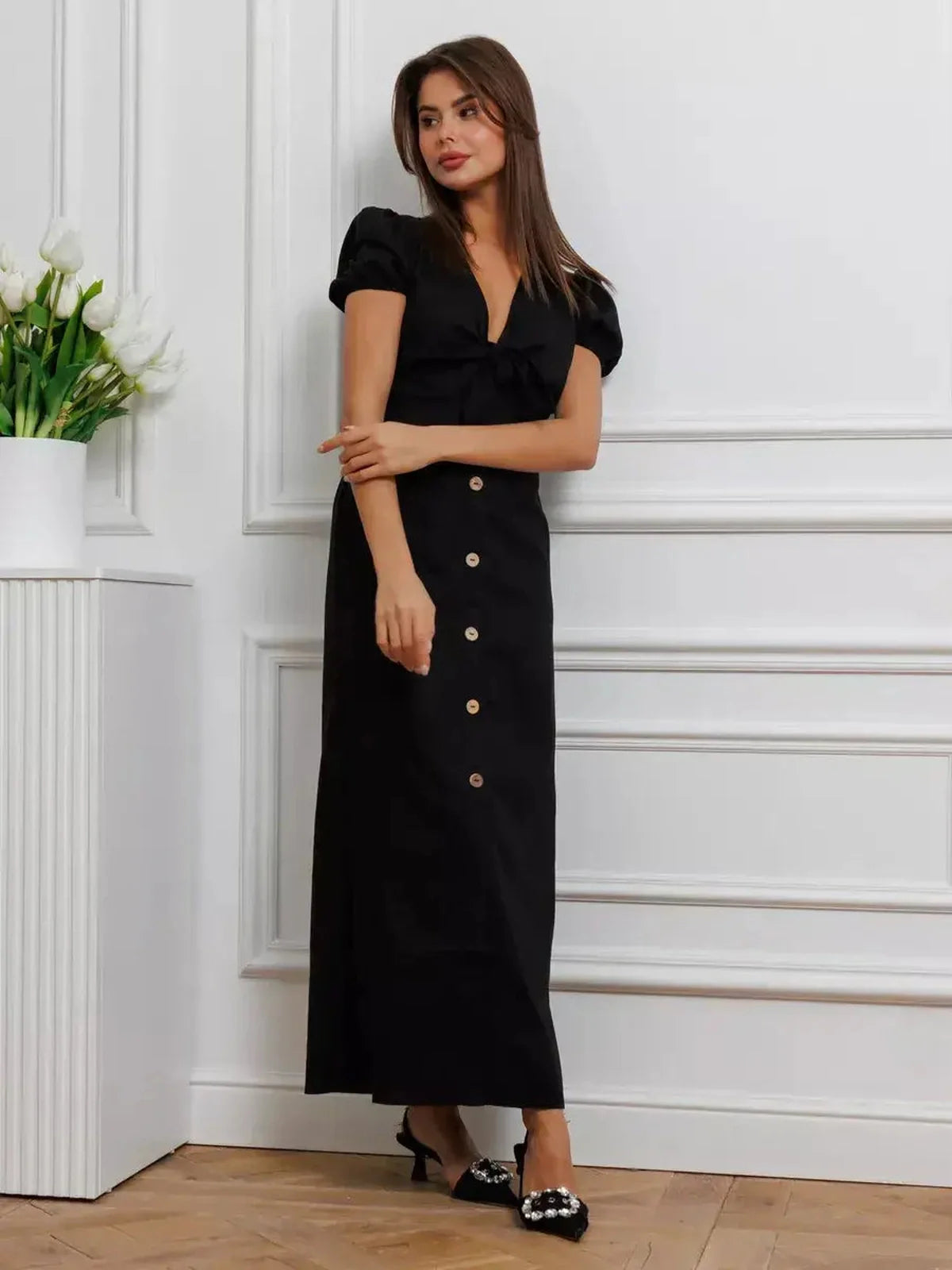 Elegant black maxi dress with tie-front, puff sleeves, and contrast buttons, perfect for formal occasions and summer events.