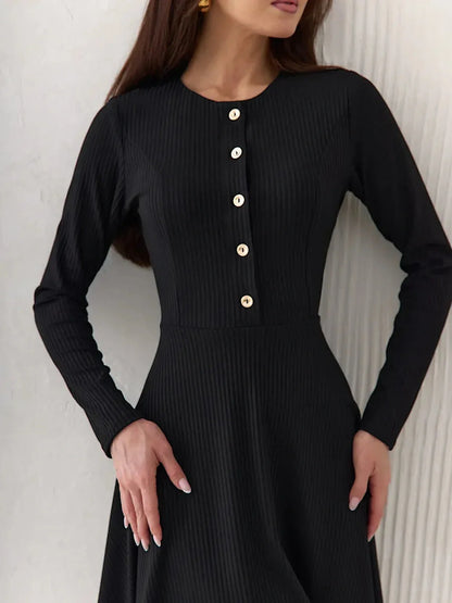 Effortless elegance in a black ribbed mini dress with long sleeves and statement buttons, perfect for various occasions.