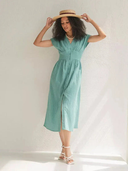Woman in a sea-green Veranda Midi Dress with a corset waist, perfect for summer outings and events.