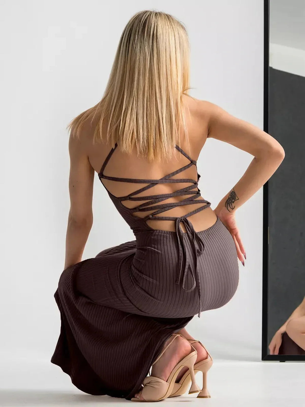 Model wearing the Obsidian Midi Dress, showcasing its strappy back and elegant silhouette.