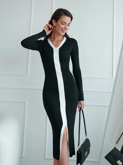 Elegant black midi dress with white contrast piping and a center slit, perfect for weddings or formal occasions.