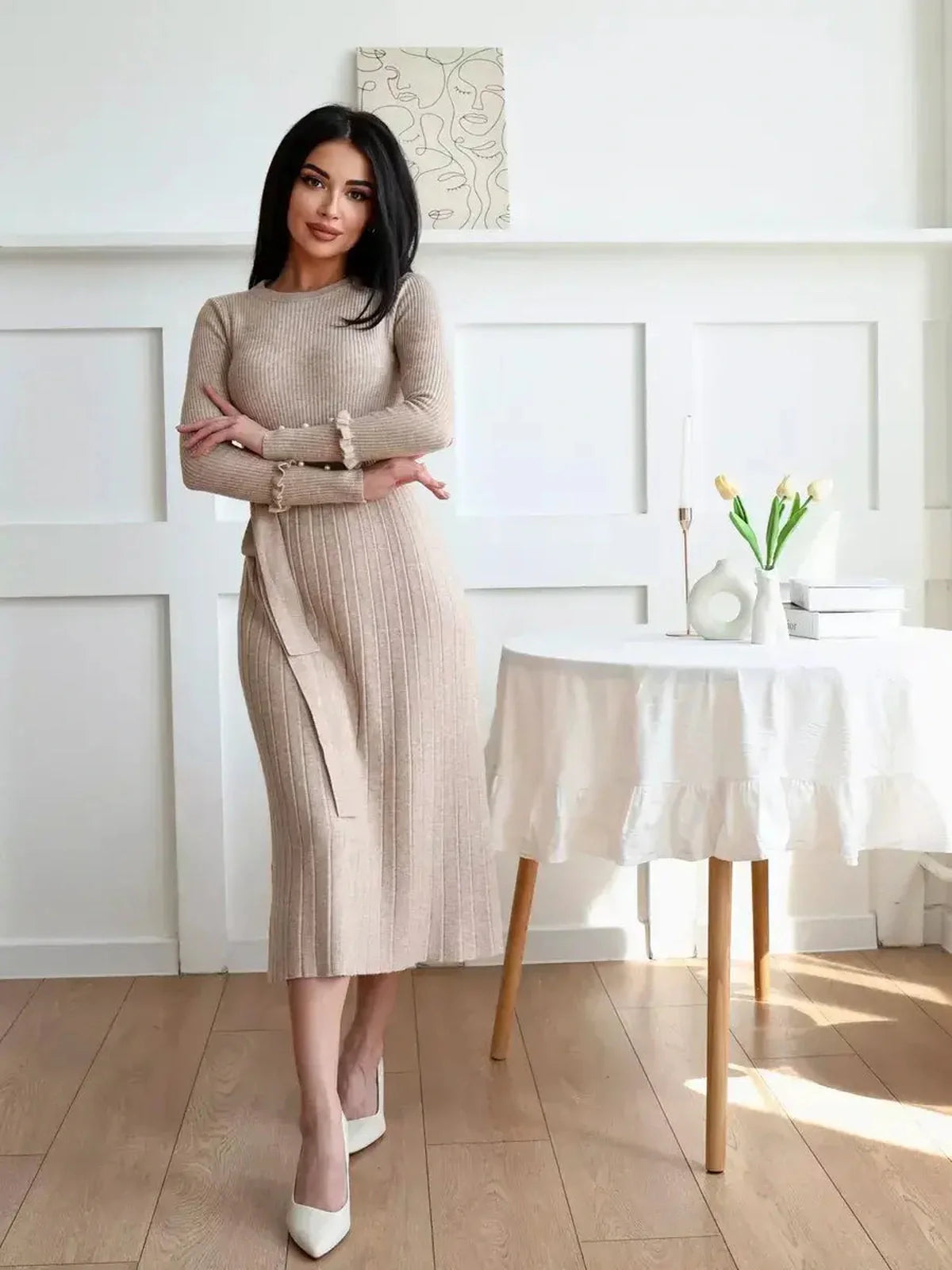 Woman in a Serene Knit Midi Dress with ribbed texture and waist tie, featuring a cozy elegance perfect for various occasions.