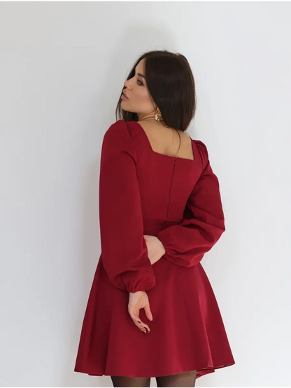 Back view of a woman in a ruby red mini dress with puffed sleeves, perfect for cocktail parties and formal occasions.