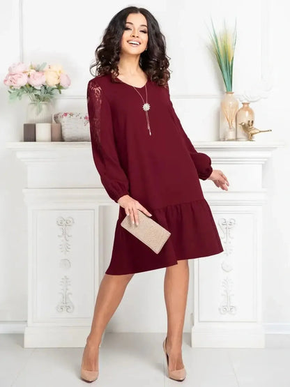 Model wearing a Lace Ruby mini dress with sheer lace sleeves, perfect for weddings and formal occasions.
