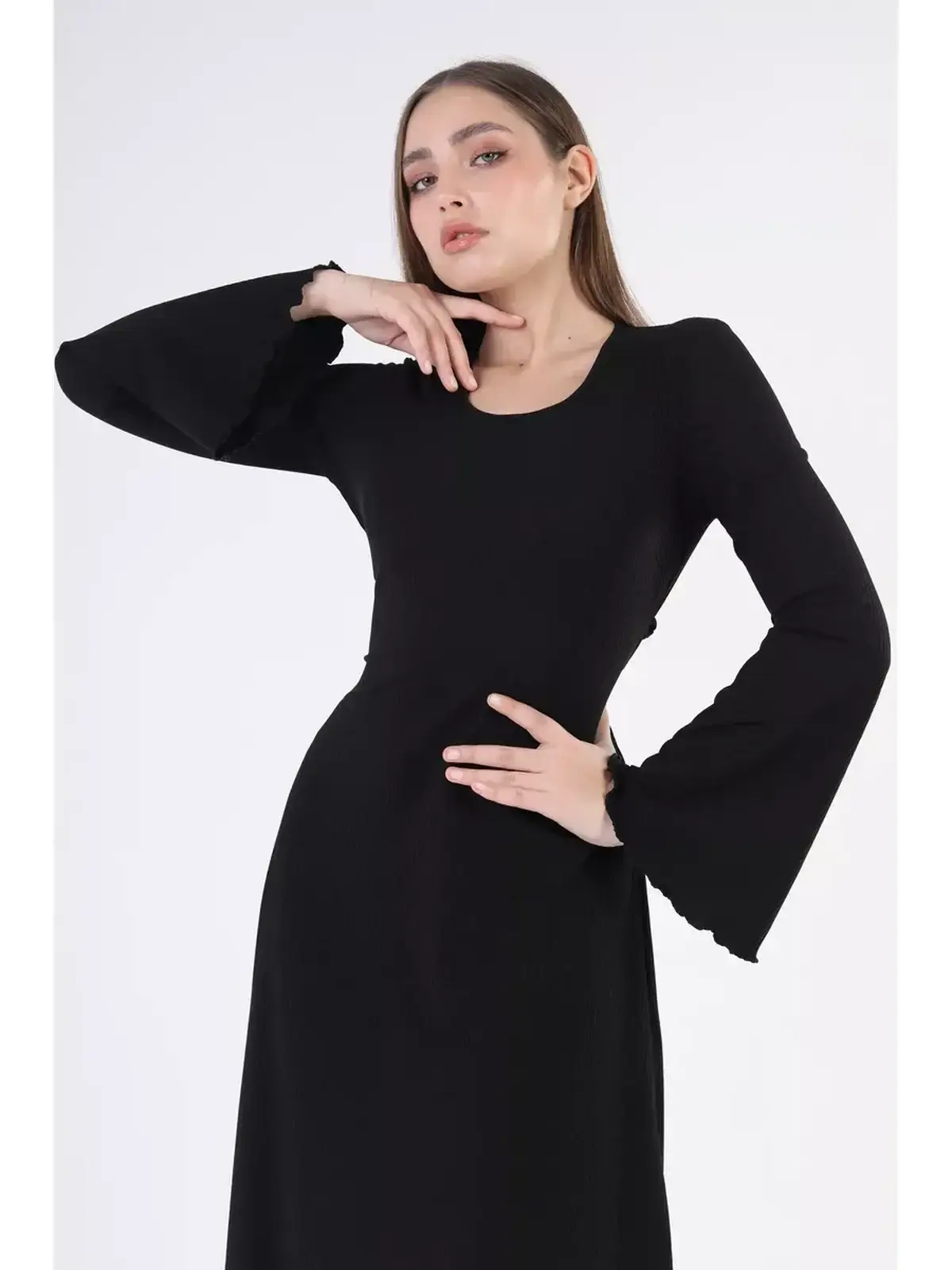 Elegant model showcasing the Noir Flare Midi Dress with bold bell sleeves in classic black.