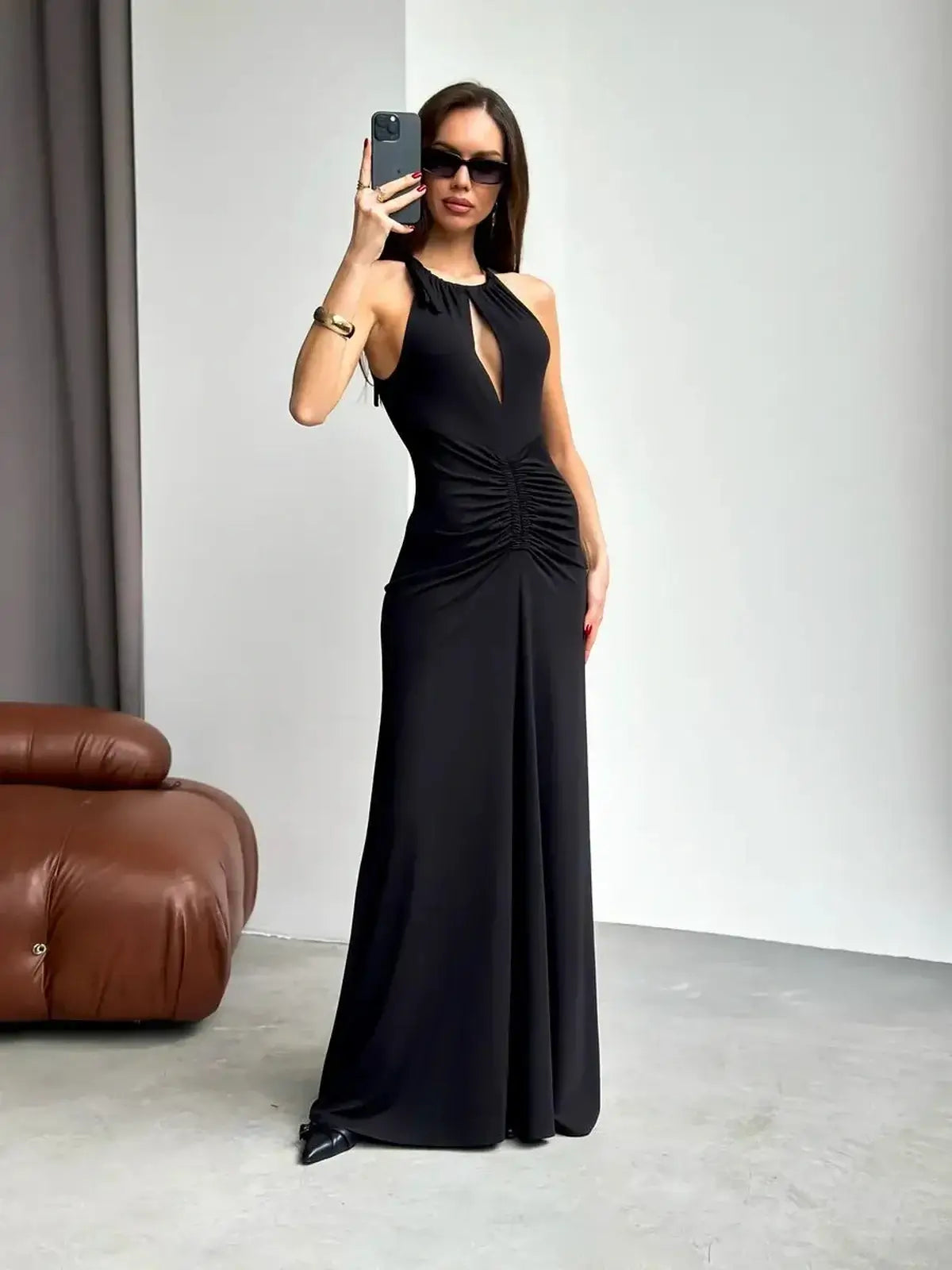 Model showcasing a stunning black maxi dress with a halter neck and keyhole cutout, perfect for formal events.