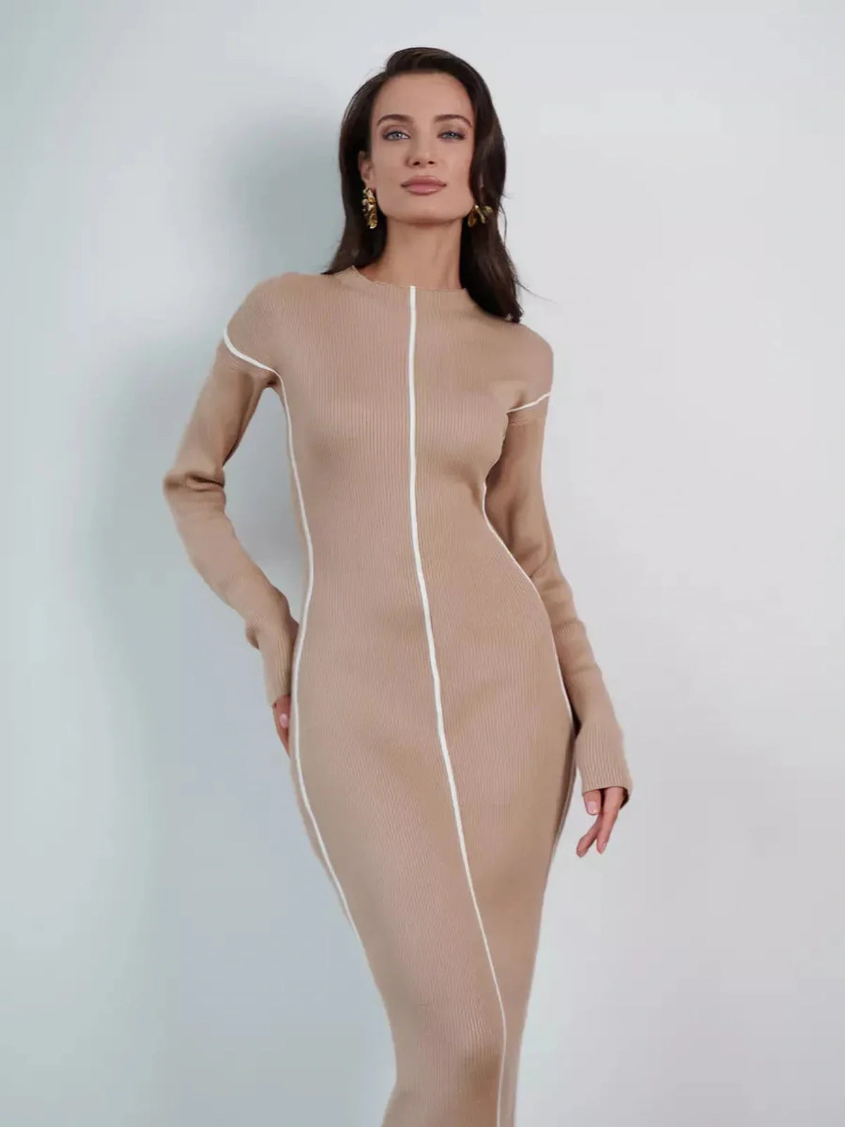 Elegant sculpted line midi dress in soft beige, featuring refined seams for a flattering silhouette.