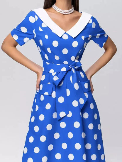 Vibrant azure blue midi dress with white polka dots, V-neckline, and tie belt, perfect for summer occasions.