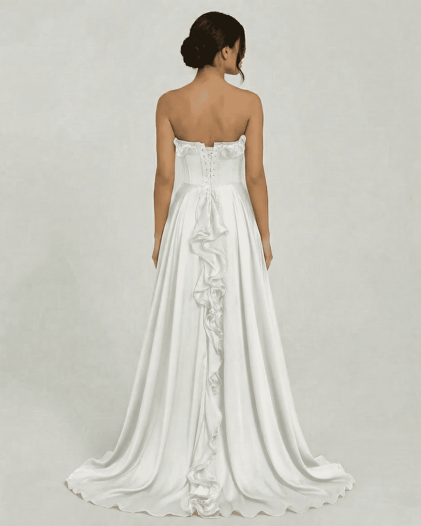 Back view of Althea Maxi Dress by Slimona, showcasing strapless design and elegant ruffle detail on a flowing white gown.