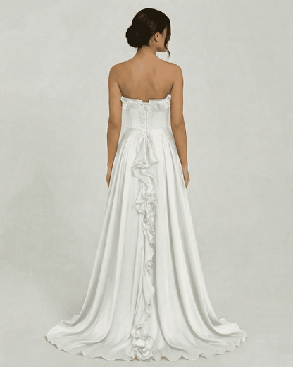 Back view of Althea Maxi Dress by Slimona, showcasing strapless design and elegant ruffle detail on a flowing white gown.