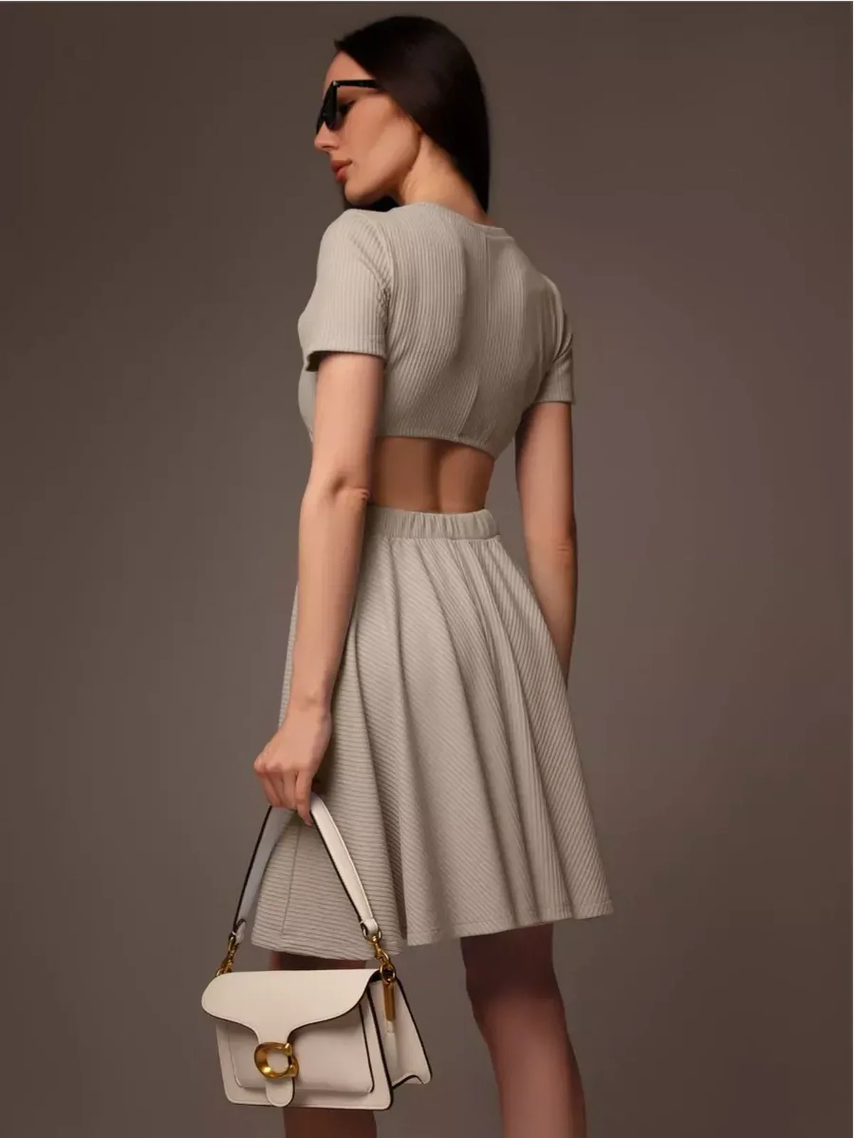 Stylish woman in a Breezy Hour mini dress showcasing a back cutout detail, perfect for summer or special occasions.