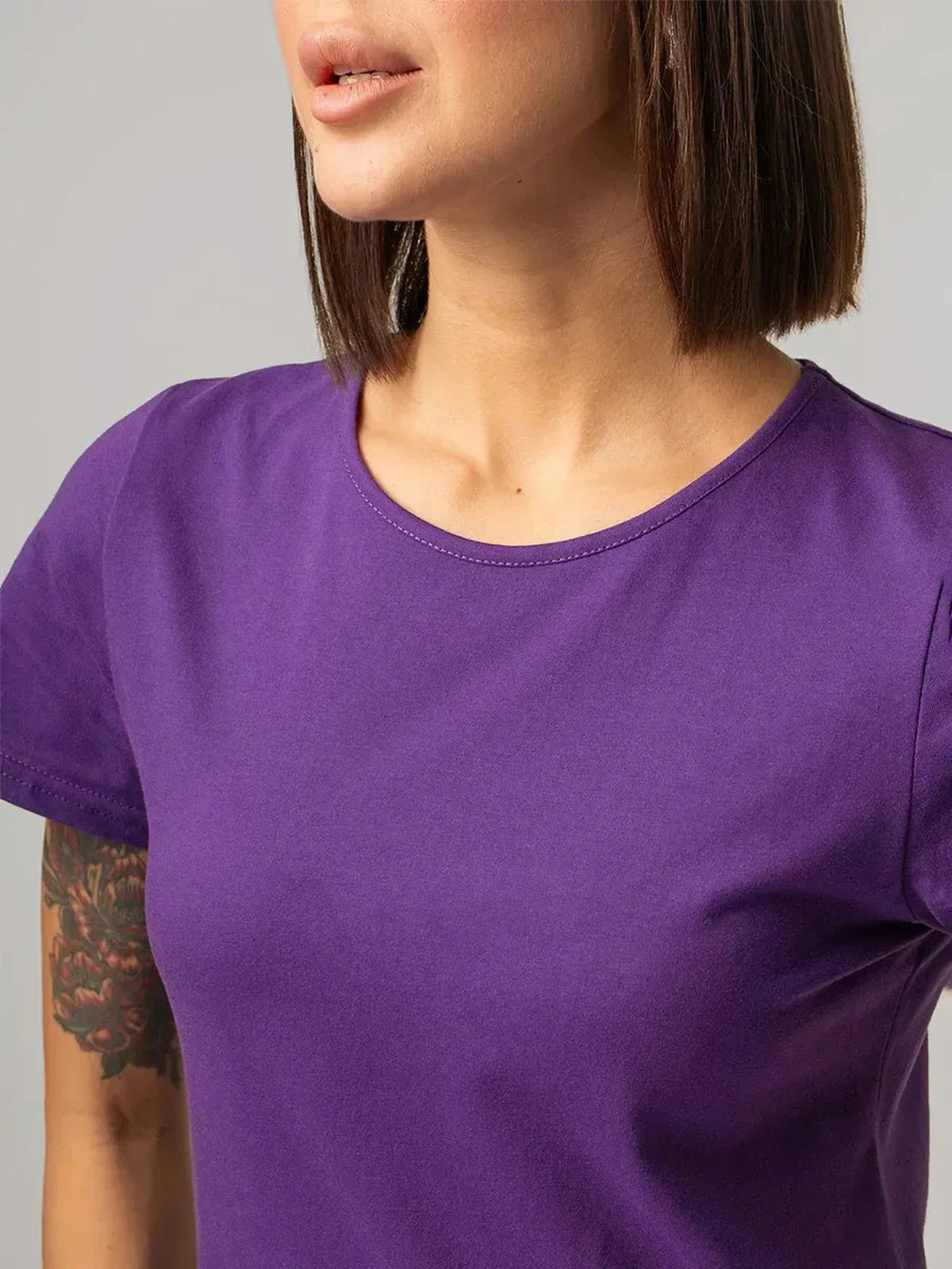 Close-up of a woman wearing a purple cotton tee, showcasing soft fabric and minimalistic design, ideal for casual wear.