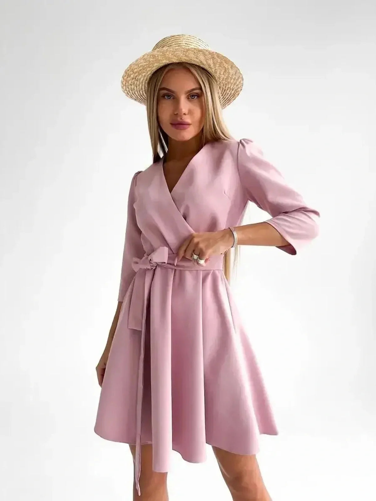 Model showcasing a pink mini dress with a V-neckline and belt, perfect for summer weddings and formal occasions.