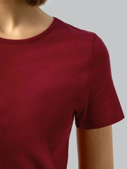Close-up of a woman wearing a burgundy midi dress featuring a minimalist design and short sleeves.