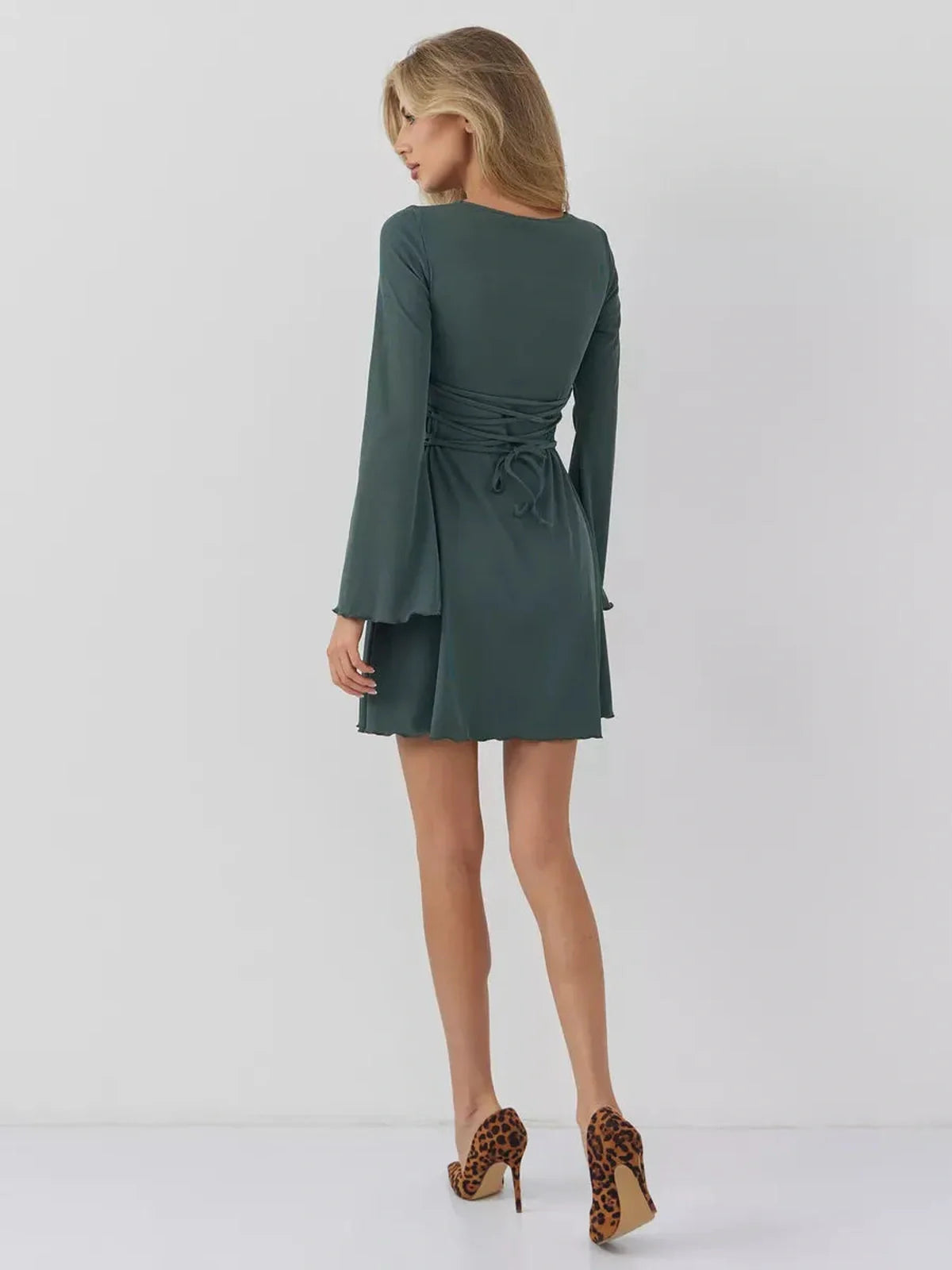 Back view of a woman wearing a dark olive mini dress with bell sleeves and lace-up ties, perfect for various occasions.