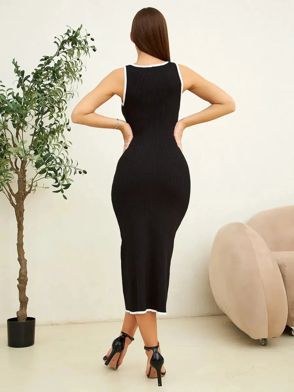 Back view of a sleek black midi dress with contrast piping, perfect for weddings and formal events.