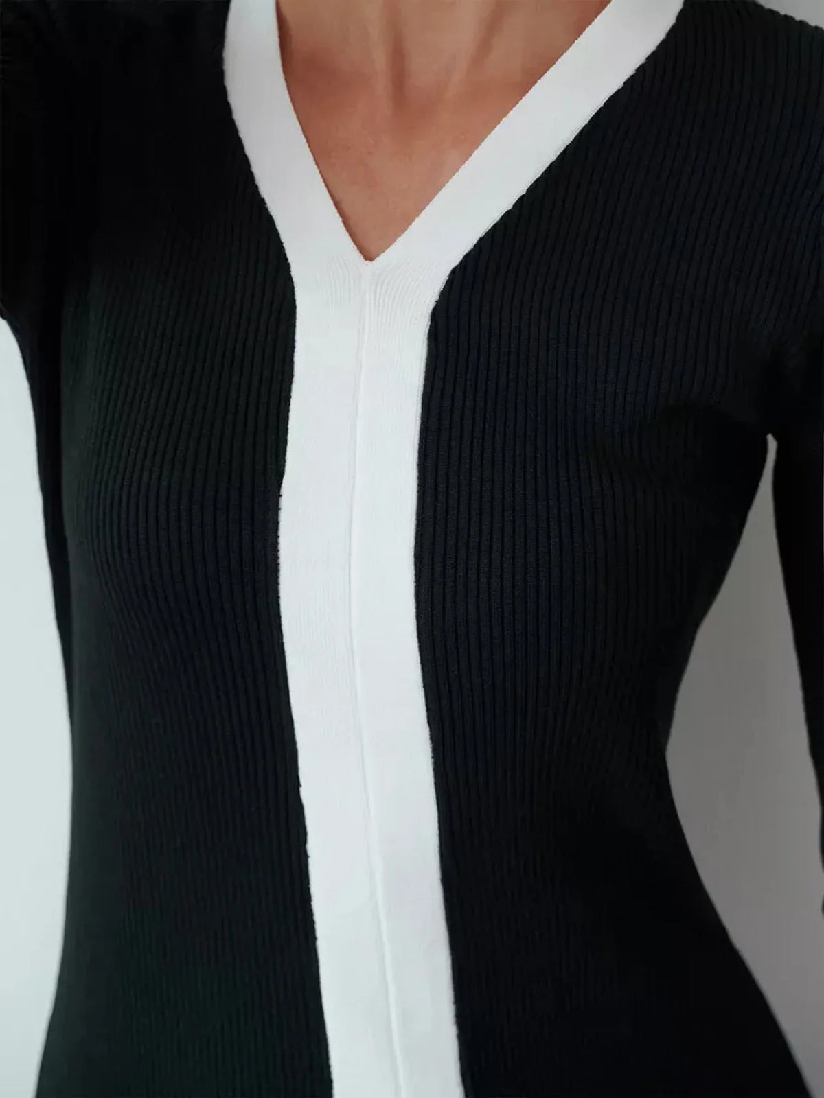 Close-up of the Contour Line Midi Dress, featuring a V-neckline with black and contrast white ribbed fabric.
