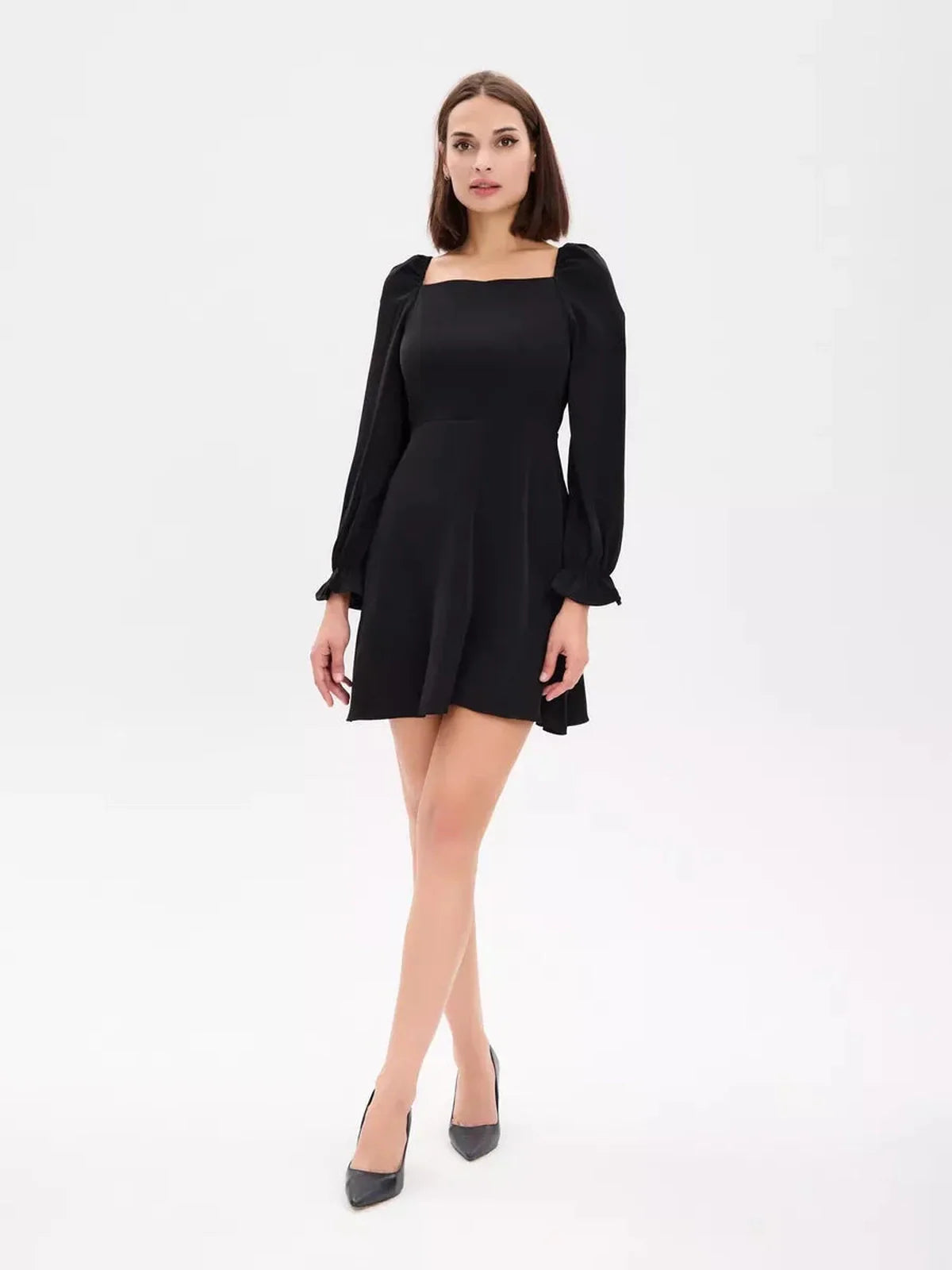 Model showcasing the Midnight Frame Mini Dress, a stylish black dress with structured sleeves and a square neckline.