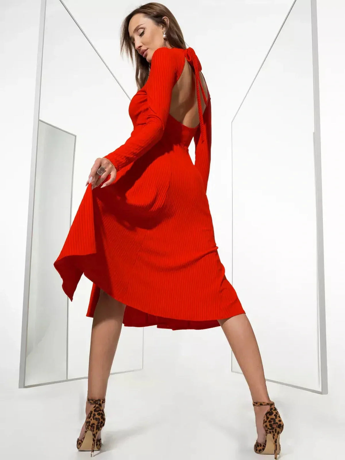 Model showcases the backless Crimson Charm Midi Dress, a vibrant red piece perfect for weddings and formal events.
