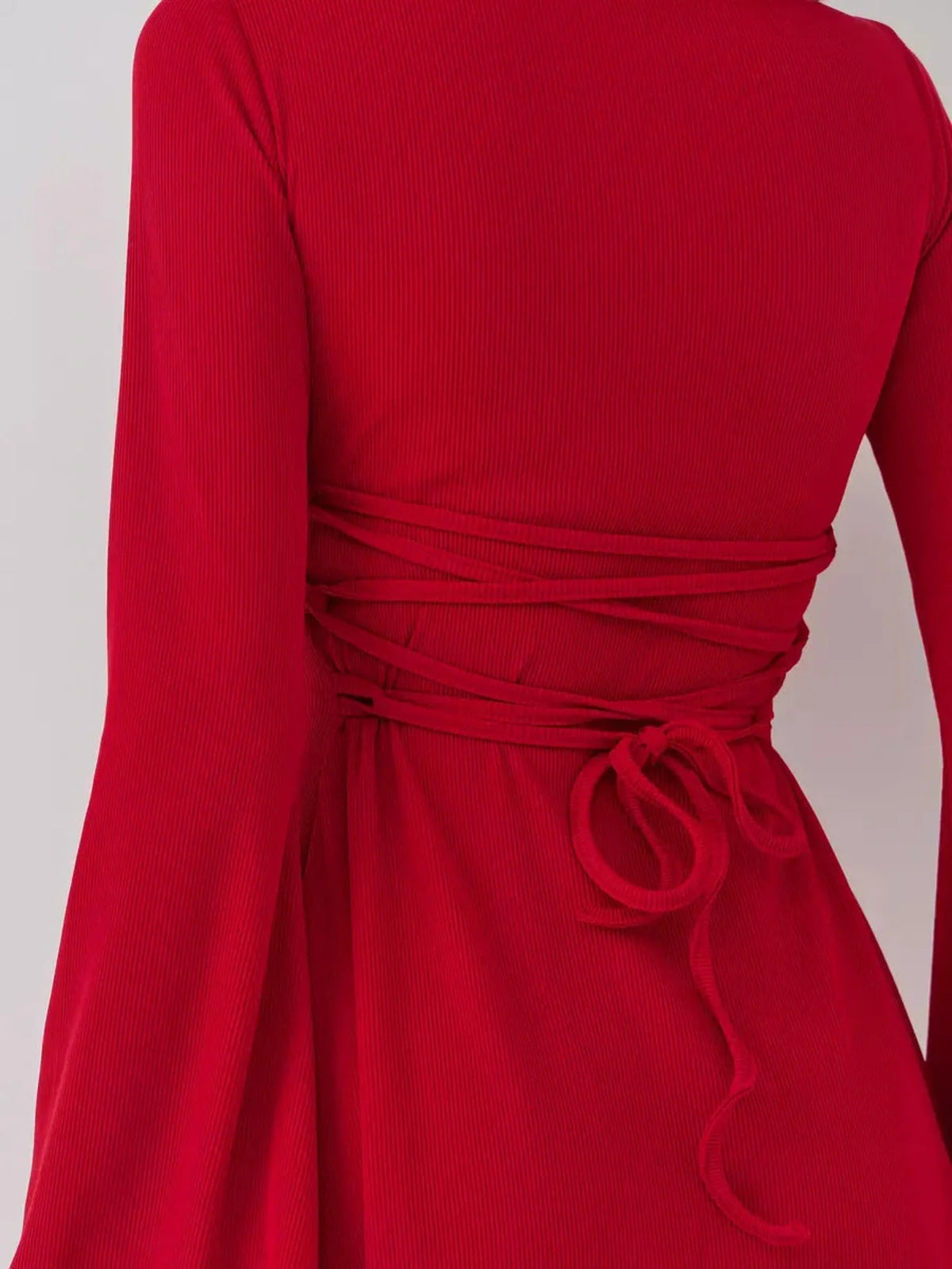 Red mini dress featuring a stylish back tie detail, perfect for cocktail events and summer occasions.