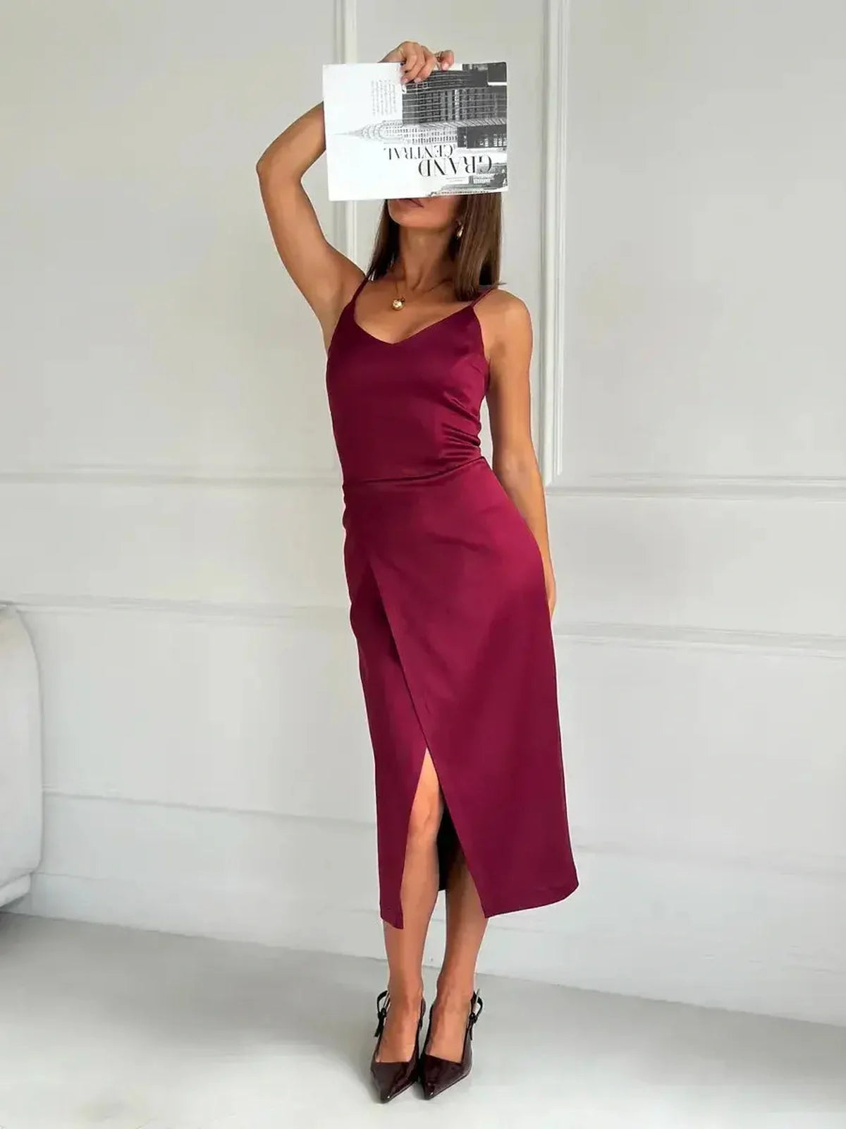 Model showcasing the Crimson Luxe Midi Dress in burgundy satin with a stylish side slit, perfect for formal occasions.
