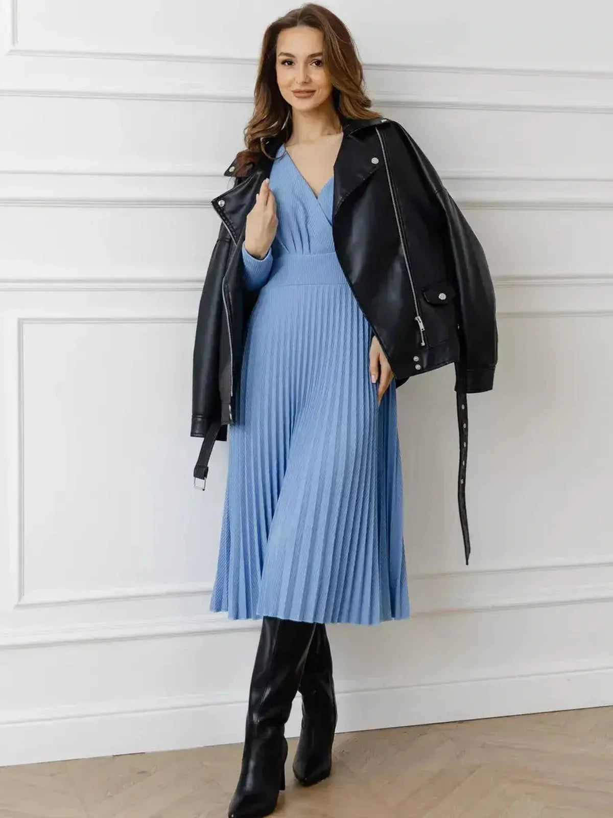 Elegant sky-blue Celeste Midi Dress with pleats, styled with a black leather jacket and tall boots, perfect for formal occasions.